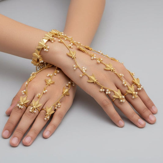 Gold hand chain worn on a hand with a blurred background